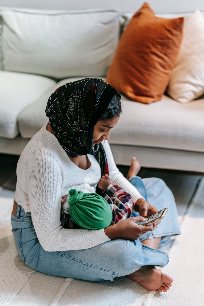 mother using phone while breastfeeding her child - manger du miel quand on allaite