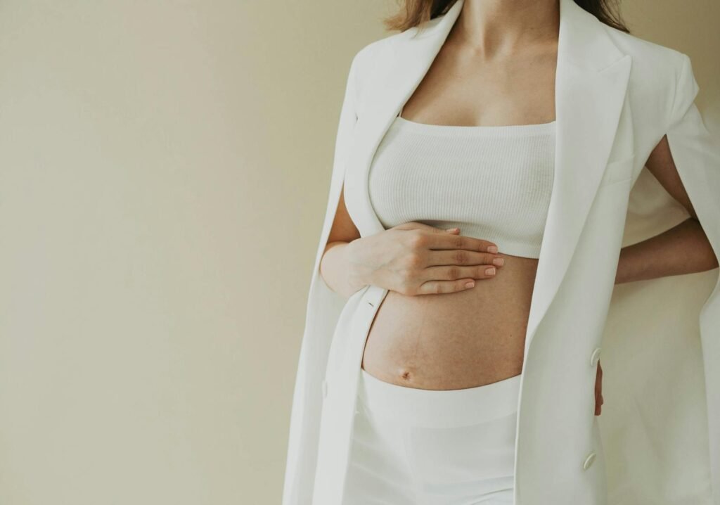 baby bump of a pregnant woman dressed in white