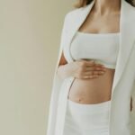 baby bump of a pregnant woman dressed in white