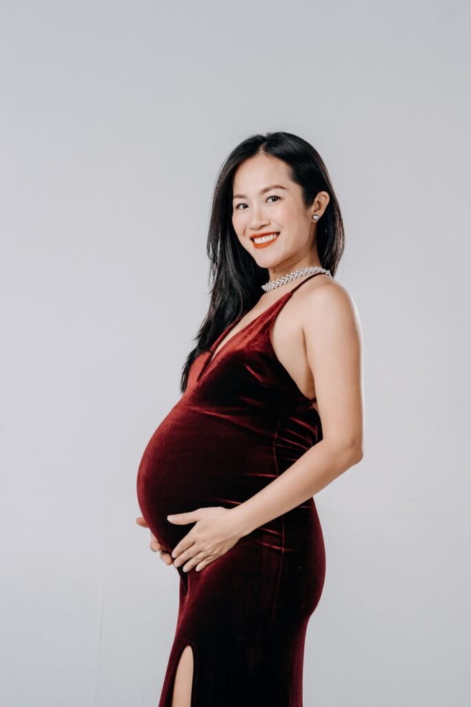 young pregnant woman standing with her hands on her belly