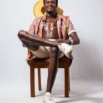 african american man sitting on brown wooden chair - chemise africaine homme