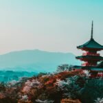 Scenic view of Kiyomizu-dera Temple with cherry blossoms in Kyoto, Japan, capturing traditional Japanese architecture at twilight.